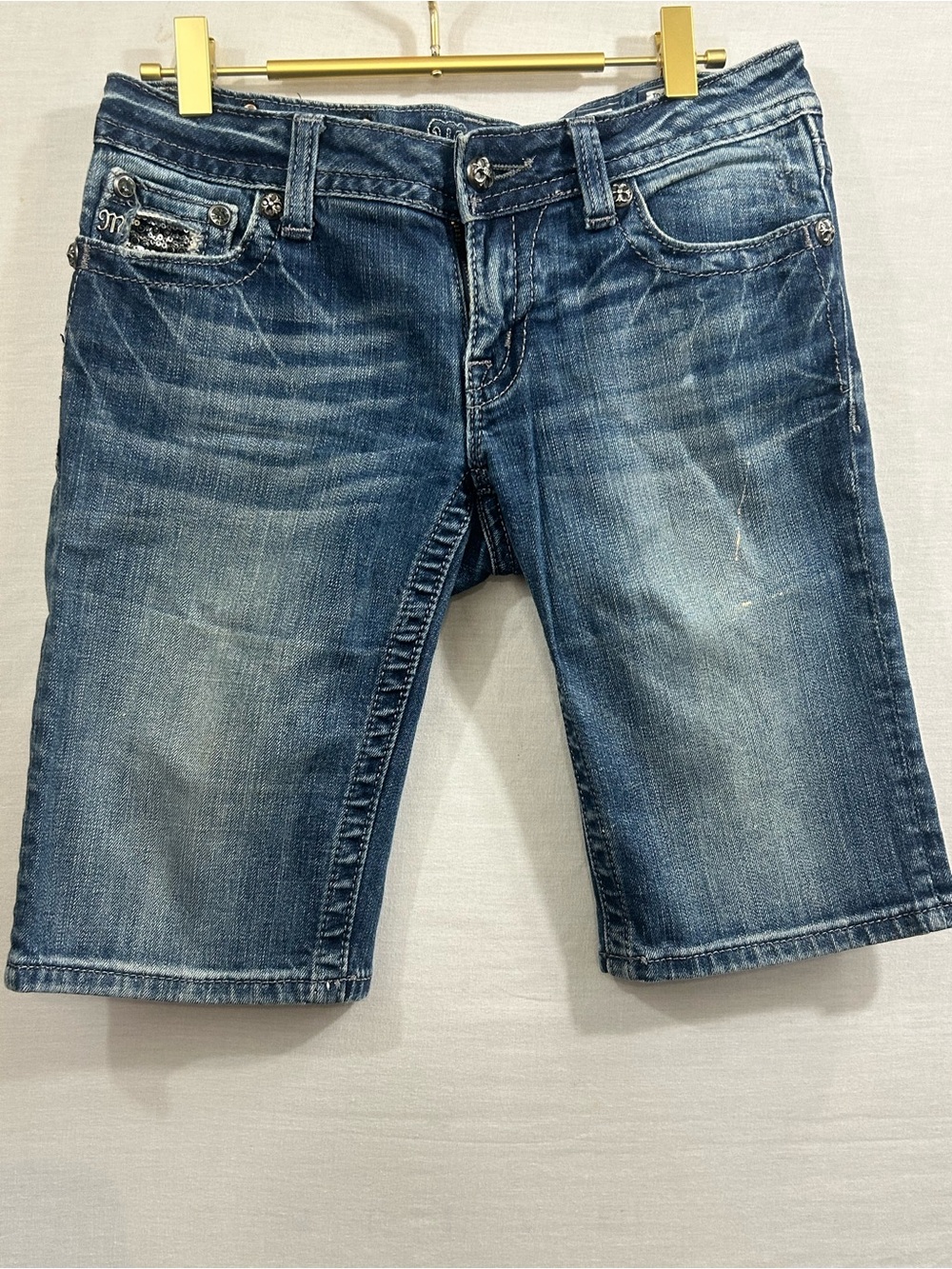 medium-wash Miss Me bermuda shorts featuring sparkle details